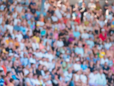 Farklı, dağınık, bulanık bir kalabalık açık gökyüzünün altındaki açık bir mekanda toplanıyor. Katılımcılar olaylarla ilgilenirken yüzler heyecanlanıyor, canlı atmosferin ve güneşli havanın tadını çıkarıyorlar..