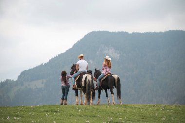 Güzel doğal bir çevre dersi sırasında profesyonel eğitmenlerin rehberliğinde atlarla kaynaşan okul katılımcılarına binmek