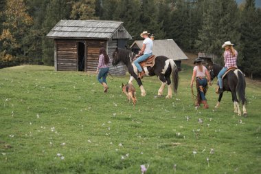 Güzel doğal bir çevre dersi sırasında profesyonel eğitmenlerin rehberliğinde atlarla kaynaşan okul katılımcılarına binmek