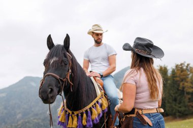 Otantik batı binicilik okulu deneyimi, kovboy at biniciliği becerilerini manzaralı bir dağ manzarasında bir bayan eğitmenden öğreniyor.