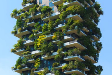 Modern bina çeşitli yeşilliklerle kaplı dikey bahçeler sergiliyor, mimariyi sürdürülebilir yaşam için doğa ile harmanlıyor.