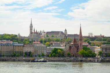 Budapeşte silueti, Tuna Nehri boyunca yeşil tepeler ve canlı binalarla tarihi ve çağdaş mimarinin bir karışımını sergiliyor. Bir köprü şehir manzarasını ve doğayı birbirine bağlar..