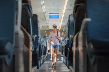 Kask takan bir kadın güneşli bir günde rahat bir şekilde rahat bir trende gezinir, muhtemelen açık hava macerasına çıkar..