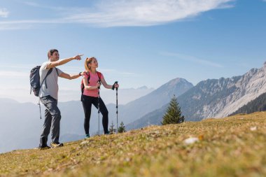 Güneşli bir günde birkaç yürüyüş, doğa tarafından çevrelenmiş güzel dağ manzarasına işaret eder..