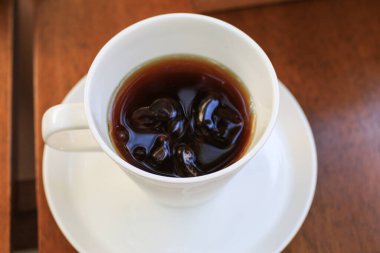 Tahta masada, beyaz fincanda sıcak kahve. Sabah kahvaltısı. Kopyalama alanı olan üst görünüm. Yiyecek ve içecek konsepti, eğlence yaşam tarzı..