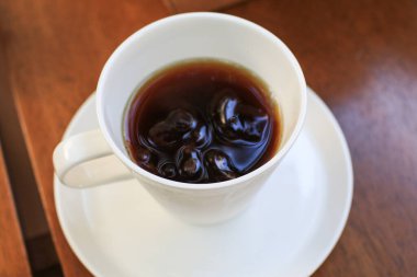 Tahta masada, beyaz fincanda sıcak kahve. Sabah kahvaltısı. Kopyalama alanı olan üst görünüm. Yiyecek ve içecek konsepti, eğlence yaşam tarzı..