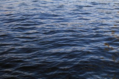 Dalgalar ve dalgalarla su yüzeylerine yaklaş ve gün batımını nehre yansıt. Pürüzsüz Doğal Tatlı Su.