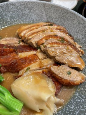 Kızarmış ördek ve sebze bir tabakta servis edilir. Geleneksel Çin mutfağı. Yemek masası..