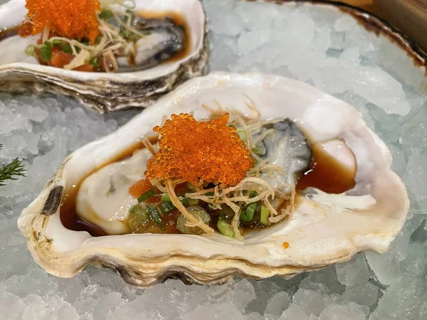 stock image Japanese Oyster on ice garnished with tobiko. Japanese appetizer or snack.