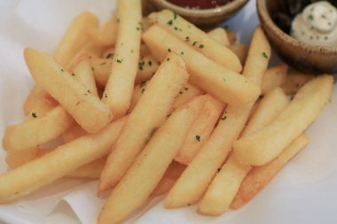 Beyaz kağıtta ketçaplı patates kızartması. Sıcak fast food. Lezzetli kızartma.