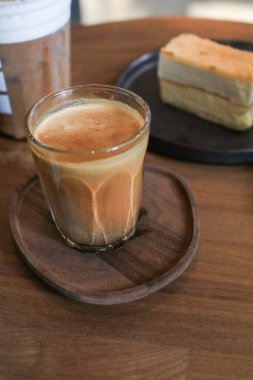 Kirli latte kahve - Bir bardak espresso ve soğuk taze sütle karıştırılmış ahşap masanın üzerindeki kafede..