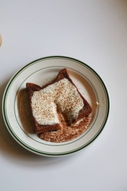 Homemade french toast with cream and cocoa powder on white background. Classic American restaurant breakfast or brunch favorite.