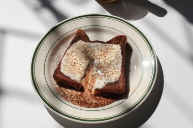 Homemade french toast with cream and cocoa powder on white background. Classic American restaurant breakfast or brunch favorite.