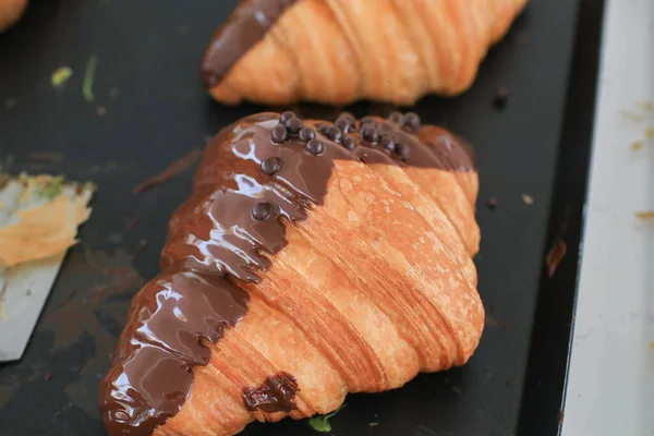 Fresh croissant with chocolate on black background. Delicious French pastry Baking Top View Copy space for Text.
