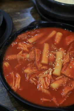 Tteokbokki in black plate. Korean rice cake stick in spicy sauce Korean cuisine dish. Street food