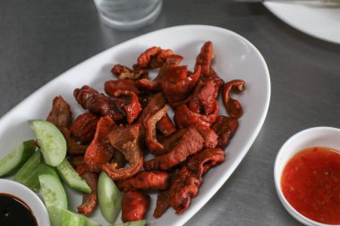 Beyaz tabakta kızarmış ördek bağırsağı. Tayland usulü kızarmış yemek. Lezzetli ve içkiyle iyi gider..