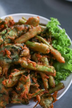 Beyaz tabakta baharatlı salata sosuyla servis edilen Çıtır Sabah Zafer Salatası. Tayland geleneksel yemekleri..