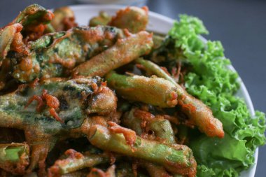 Beyaz tabakta baharatlı salata sosuyla servis edilen Çıtır Sabah Zafer Salatası. Tayland geleneksel yemekleri..