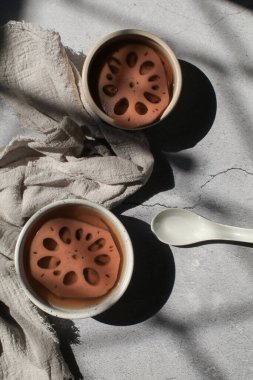 Beyaz kasede şerbetli soğuk nilüfer kökü. Tayland tatlısı. Nilüfer kökü eşsiz bir özelliğe sahiptir. Bu da sağlığa iyi gelir.