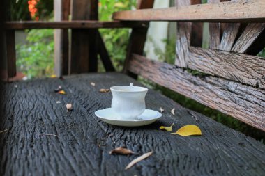 Sonbahar yapraklı beyaz kahve fincanı ve ahşap masanın üzerinde gölge. Kahvaltı atıştırmalığı konsepti. Kopyalama alanı olan üst görünüm. Sonbahar sezonu konsepti.