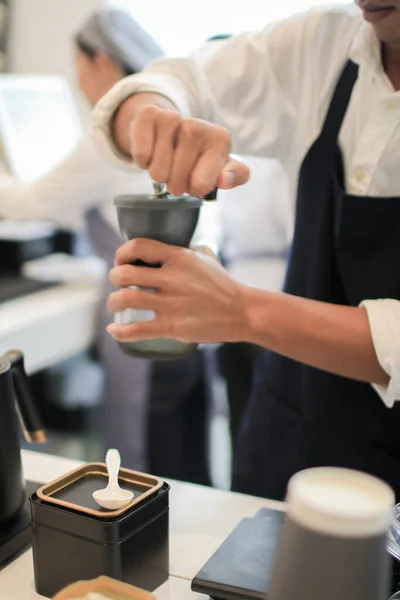 バリスタコーヒードリッパーと漏斗に挽いたコーヒーとフィルターを注ぐ 醸造プロセスでレストランやカップで働く コーヒーショップのコンセプト — ストック写真