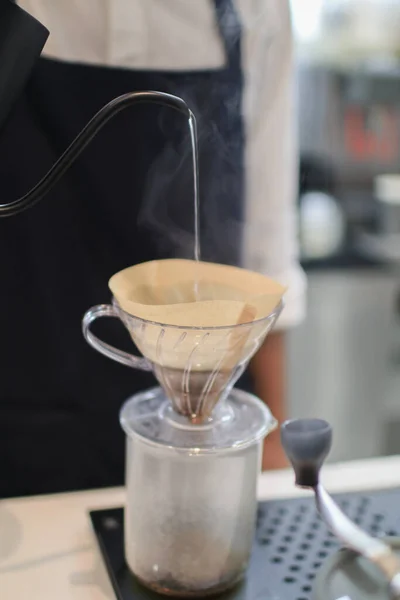 stock image Barista coffee dripper and pour over filter with ground coffee in the funnel. Working in restaurant and cup with brewing process. Coffee shop concept.