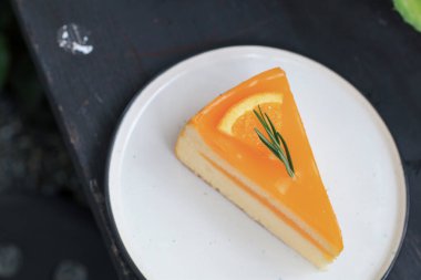 Beyaz tabakta taze portakal dilimli turuncu pasta. Tatlı ve desenli arka plan. Kırsal biçim