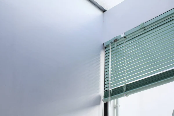 Aluminum window rolling blind. White plastic window with blinds close-up. Interior design.