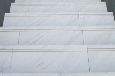 Koridorun beyaz mermer merdivenleri ve güneş ışığı. Güzel doğal taştan modern bina. Minimum arkaplan. Öğleden sonra havasında arka bahçede..