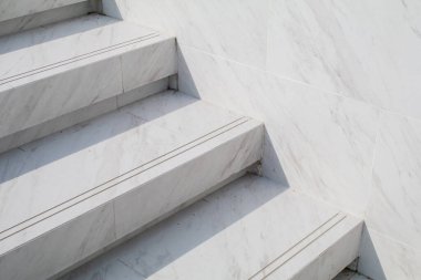 Koridorun beyaz mermer merdivenleri ve güneş ışığı. Güzel doğal taştan modern bina. Minimum arkaplan. Öğleden sonra havasında arka bahçede..