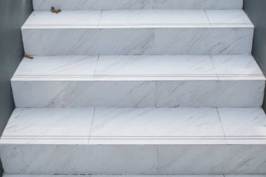 Koridorun beyaz mermer merdivenleri ve güneş ışığı. Güzel doğal taştan modern bina. Minimum arkaplan. Öğleden sonra havasında arka bahçede..