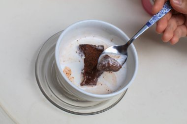 Beyaz kasede sütlü siyah çikolatalı kek. Sağlığa iyi gelir. Süte batırıp browni yemek eğlencelidir..