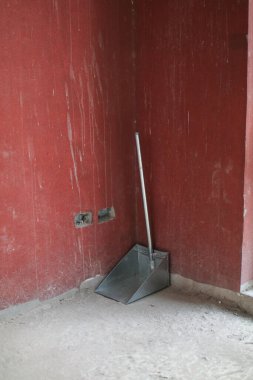 Kırmızı arka planda uzun saplı demir faraş ve fotokopi alanı. Süpürme ve Temizleme, El ile Temizleme Malzemeleri.