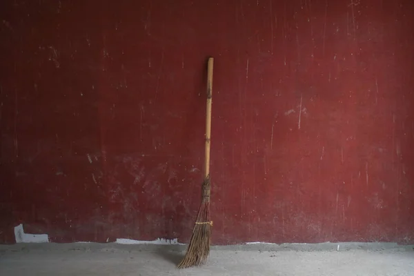 stock image Broom from rods with wooden handle on red background. Hygiene and home cleaning. Tool for home or room Cleaning.