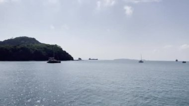 Lüks yatların ve Phuket adasında yelkenli teknelerin ziyaret ettiği tropik cennet gibi berrak plajlar. Plaj manzarası ve tekneli güzel mavi okyanus..