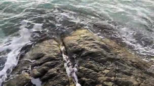 파도가 절벽에 부서집니다 해변에 해안의 바위에 — 비디오