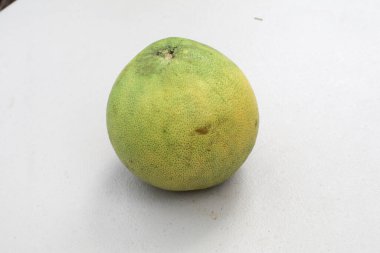 Bahçedeki beyaz masada yeşil nar meyvesi. Sonbahar festivali meyvesi. Taze ve lezzetli tropikal meyve. Bahçedeki masa. Sonbahar festivali meyvesi. Taze ve lezzetli tropikal meyve.