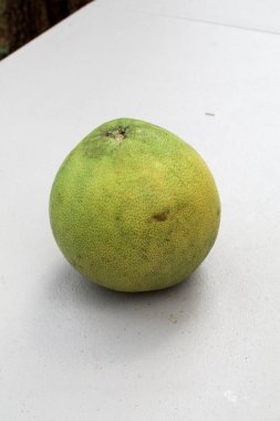 Bahçedeki beyaz masada yeşil nar meyvesi. Sonbahar festivali meyvesi. Taze ve lezzetli tropikal meyve. Bahçedeki masa. Sonbahar festivali meyvesi. Taze ve lezzetli tropikal meyve.