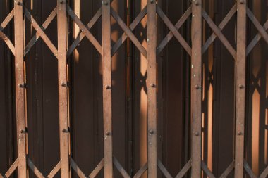 Rusty Steel eski kapıyı katlıyor. Gölge ve güneş ışığıyla birlikte. Demir kapı vintage tarzı. Doku ve arkaplanı kapat.