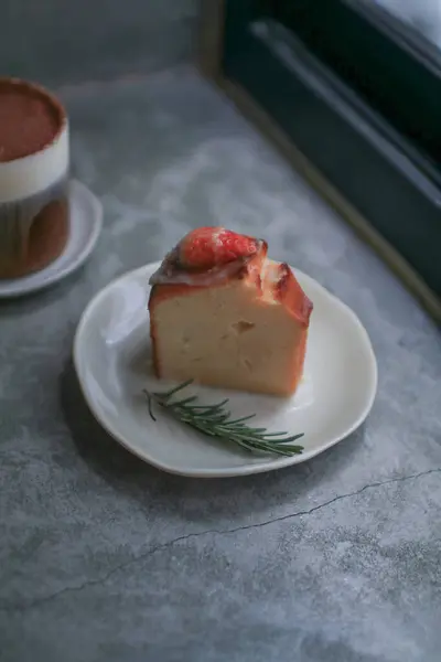 Basque burnt cheesecake with fresh strawberries on white plate cement floor background. Japanese desser.