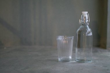 Gri arka plan zemininde bir şişe su. Sağlıklı bir yaşam tarzı. Temiz ve taze içme suyu şişesi