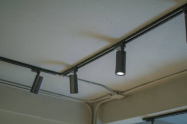 Tavanda parlak siyah ışık var. Modern LED sallanan döner spot lambası. Kolyenin içi.