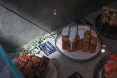 Gri ışıklı beton arka planda güneş ışığı altında kabak peynirli kek. Uzayı kopyala Şükran Günü, aşçılık, tarif, menü konsepti..