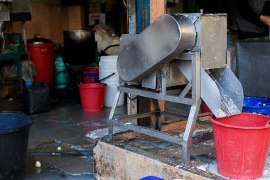 Hindistan cevizi lapası yapmak için hindistan cevizi kazıyıcısı. Hindistan cevizini rendelemeyi kolaylaştıran teknoloji..