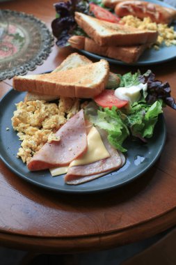 Amerikan kahvaltı yumurtası, jambon, sosis, pastırma, domates, ekmek ve salata. Sabahları sağlıklı besleniyorlar..