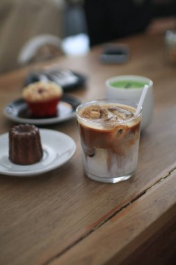 Ahşap masada fırınlı buzlu latte kahve. Ev yapımı kahvaltı Kafedeki bir kafede.