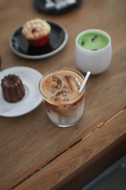 Ahşap masada fırınlı buzlu latte kahve. Ev yapımı kahvaltı Kafedeki bir kafede.