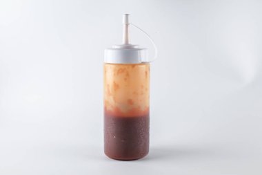 Beyaz arka planda ketçap soslu sıvı gıda konteynırı plastiği.