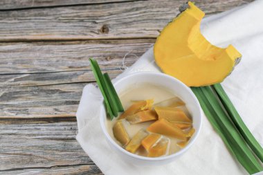 Hindistan cevizi sütlü balkabağı, ahşap masada, palmiye şekerli. Gelenek Tayland Tatlı Tatlısı.