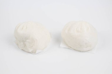 Bambu dilimleme tahtasının üzerinde domuz kıymalı buğulanmış çörekler. Beyaz arka planda Çin yemeği Dim Sum tarzı. Kahvaltı Asya yemekleri..